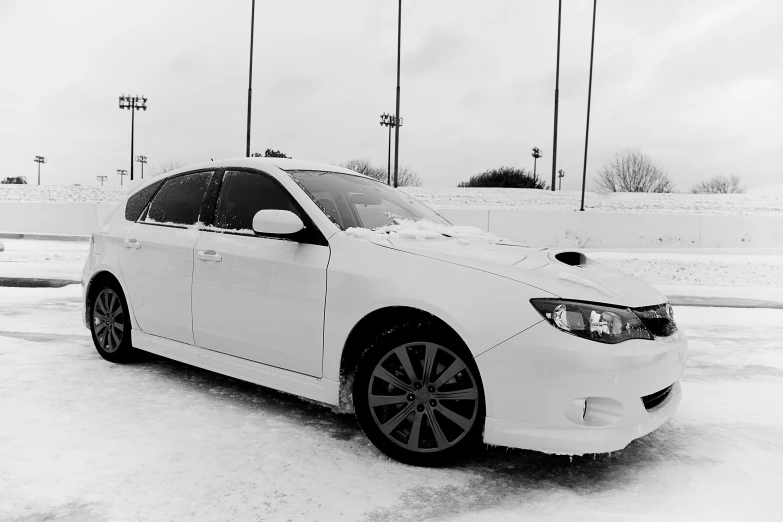 a white sedan parked in the snow under lights