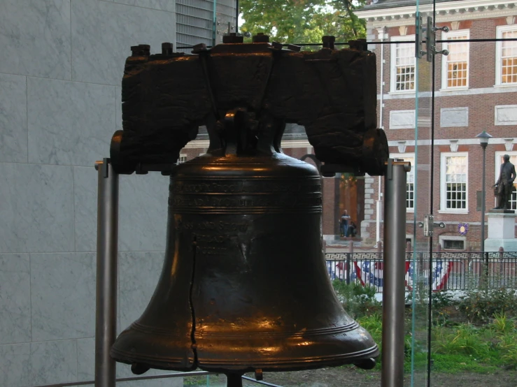 an old bell with a sign on the wall