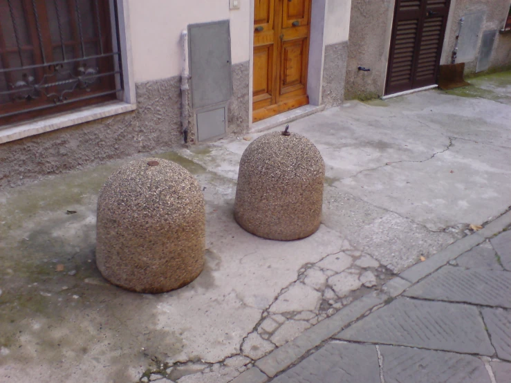 two stone balls sitting outside of a building