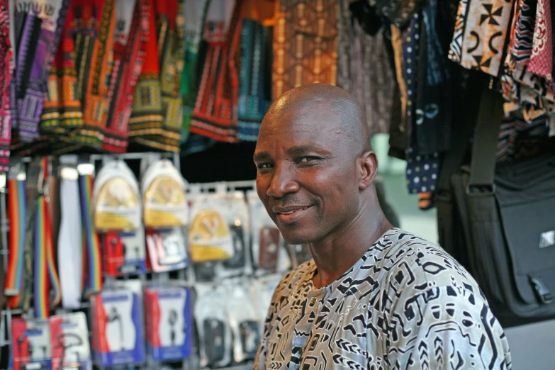 a man wearing a patterned shirt next to the clothes shop