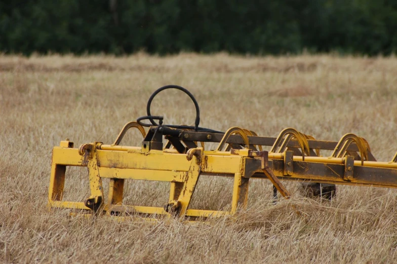a big farm equipment is sitting in the middle of a field