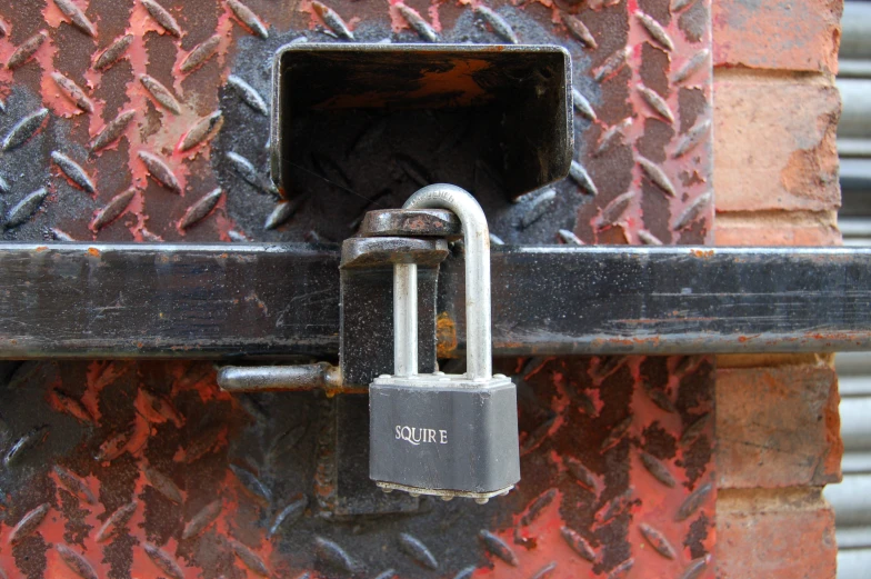 the handle lock is hanging on a rusty door