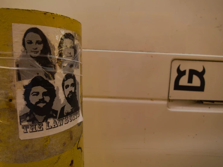 a picture of three faces in different black on a sticker near a wall