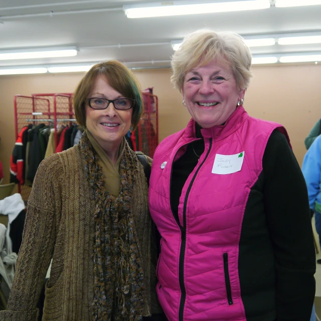 two women stand in a store posing for a po