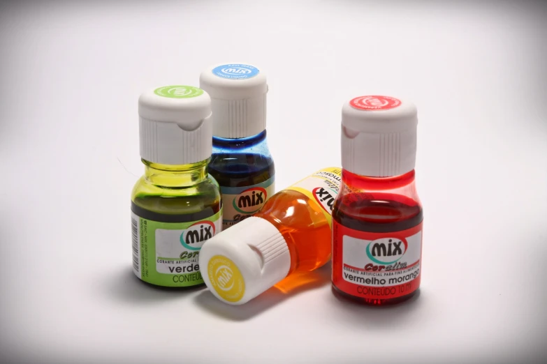 five different colored medical drops on a white surface