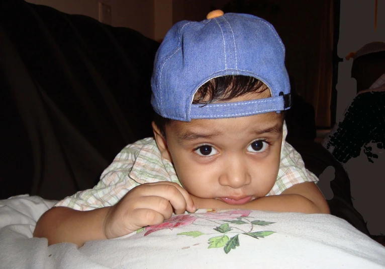 a close up of a child wearing a blue hat