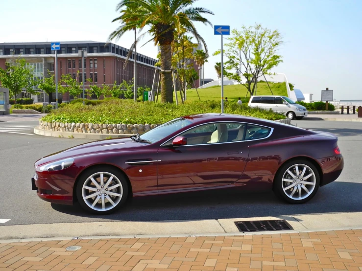 the beautiful red sports car is parked next to a large building