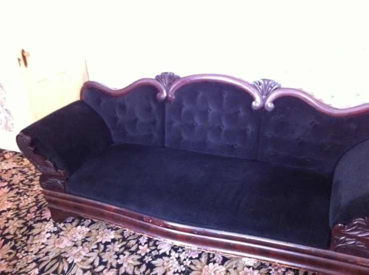 a couch with an ornate design and wooden feet