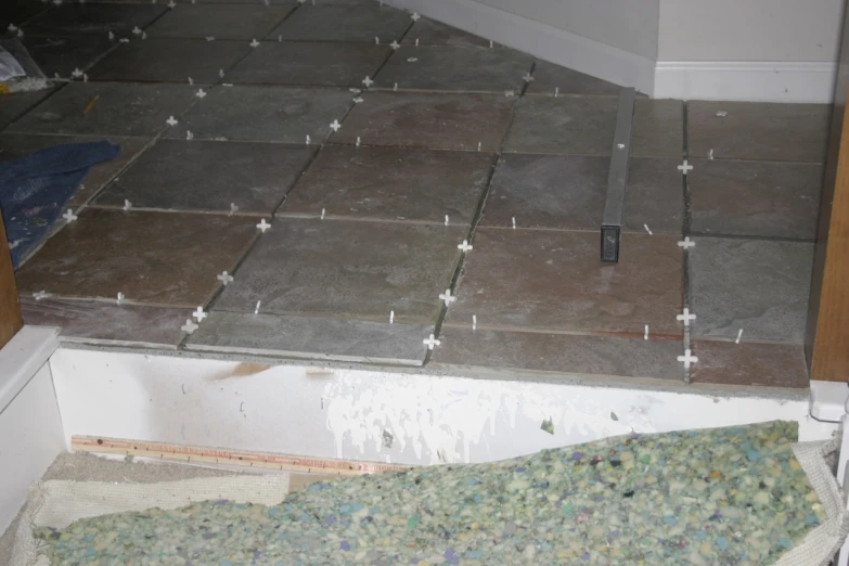 a tile floor with several square tiles and screws