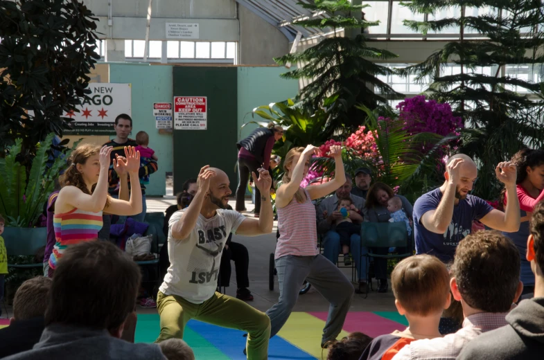 people are dancing around a colorful area on colorful rugs