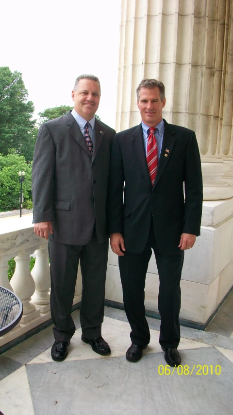 two men in suits standing on steps near one another