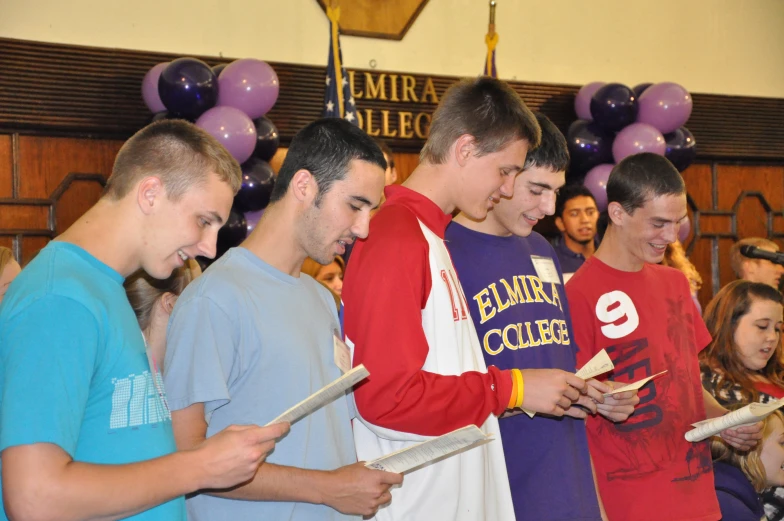 a group of young people are looking at some papers