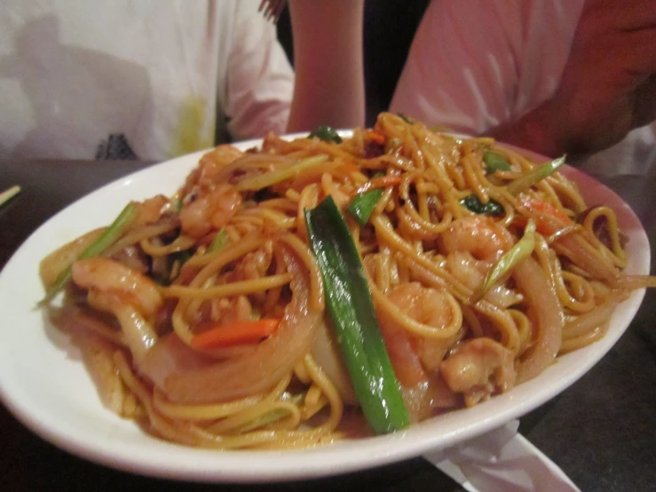 a plate with noodles, chicken and vegetables on it