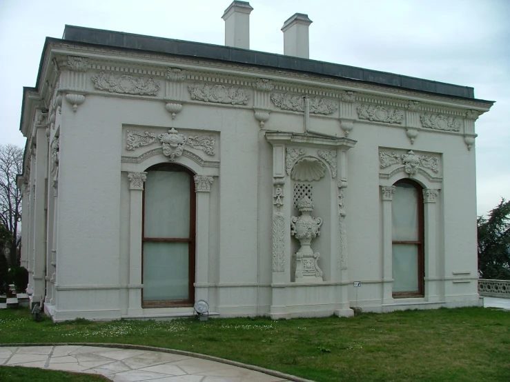 a white old style building with two big windows