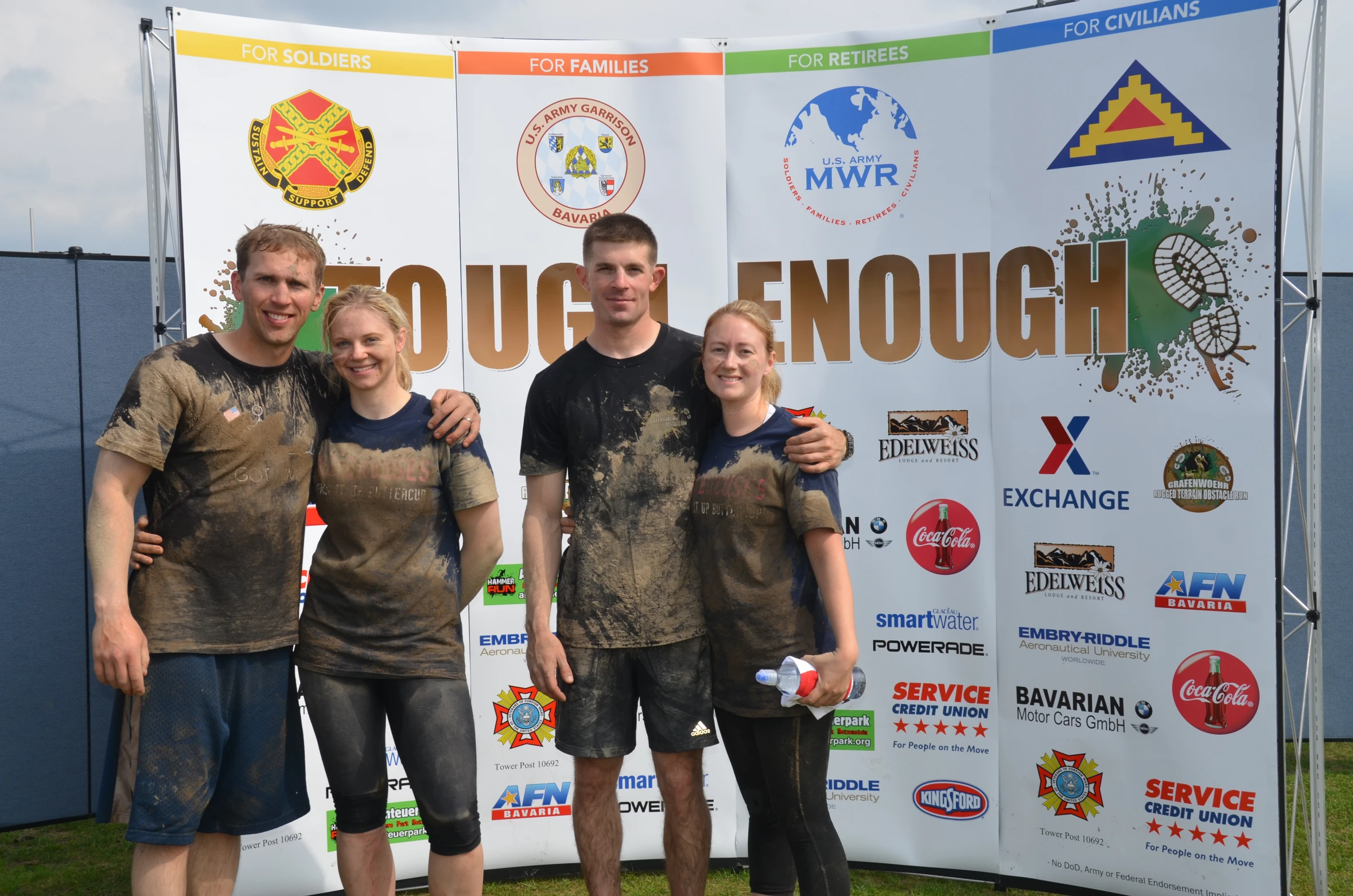 four friends are standing by a sign that says enough