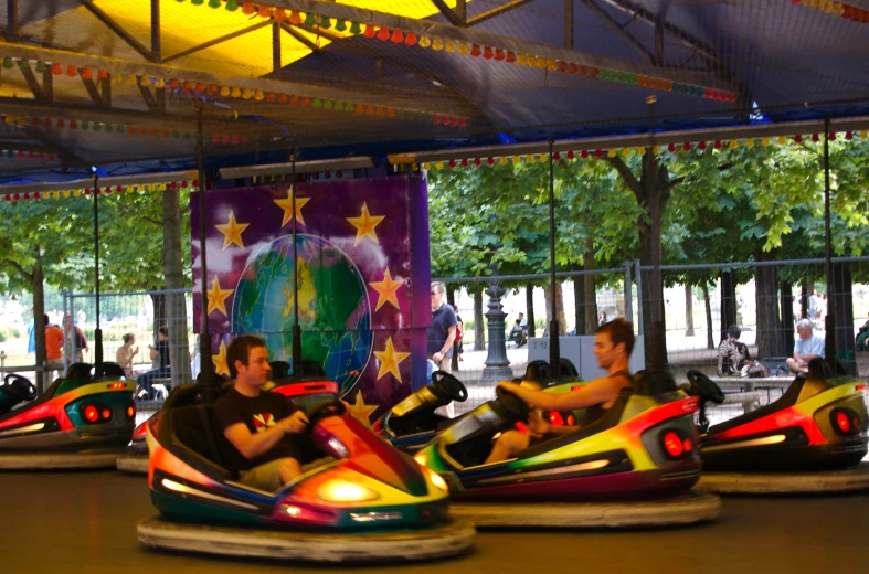 a couple rides bumper cars inside of a carnival