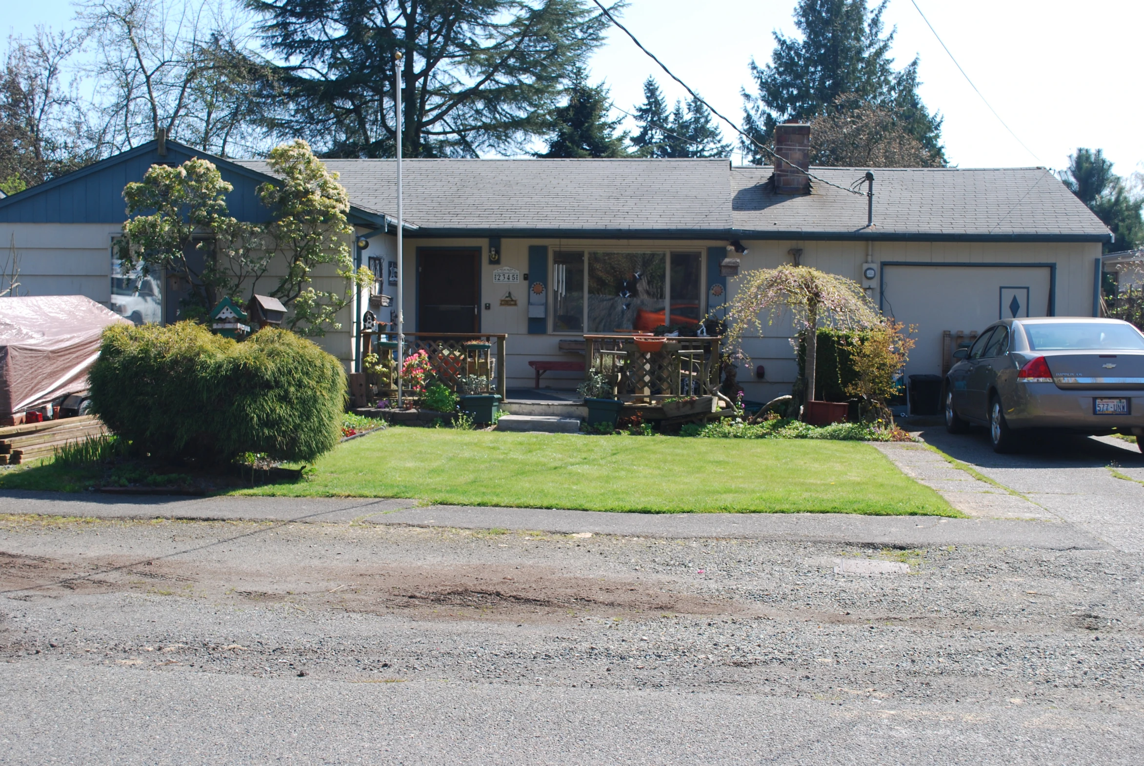 a very nice home with some plants and bushes on the front