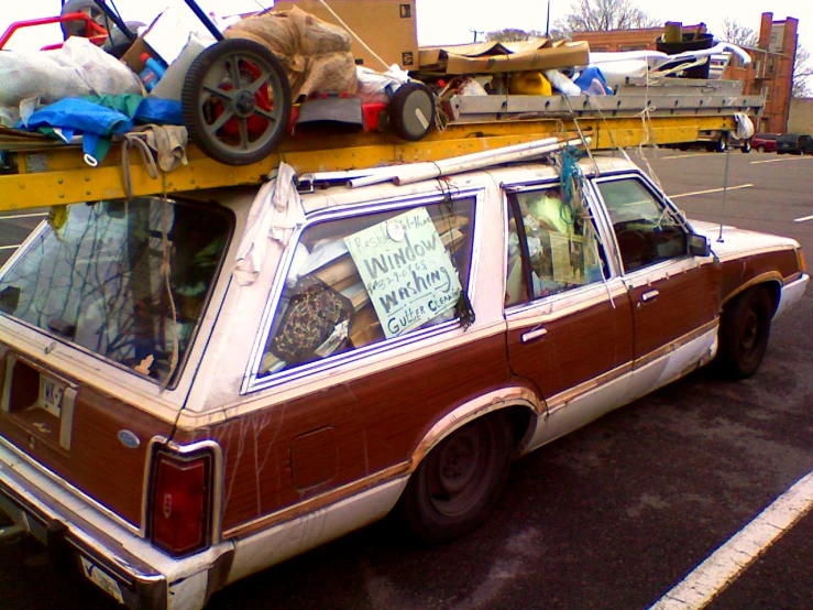 an old station wagon with several boxes on top of it