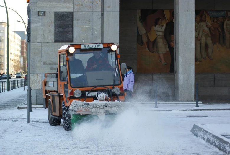 a city snowplow is moving through the snow outside