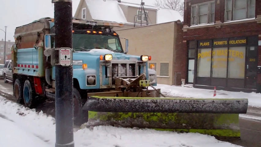 a trash truck that is parked next to a street