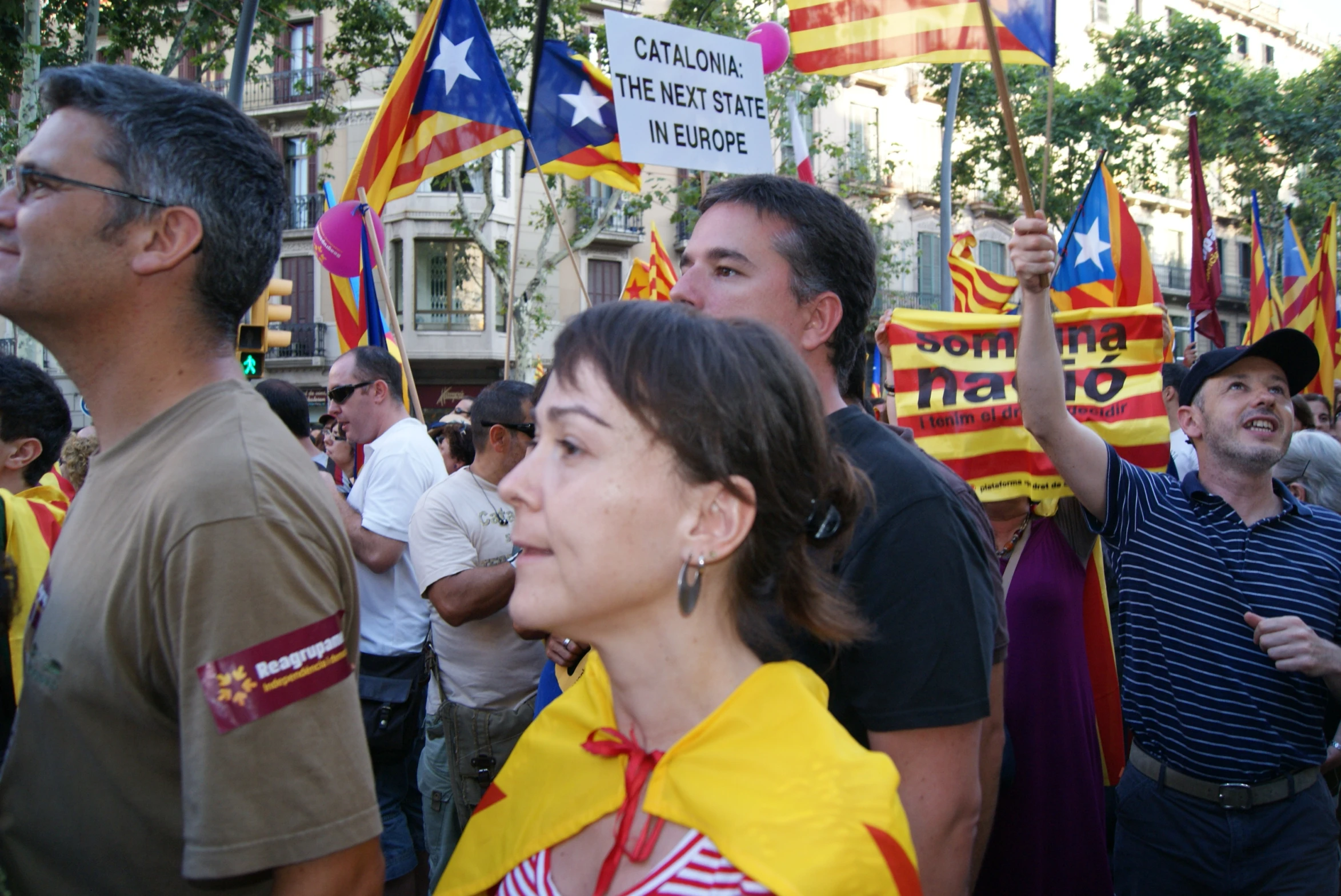 a woman standing at the top of a hill holding a sign