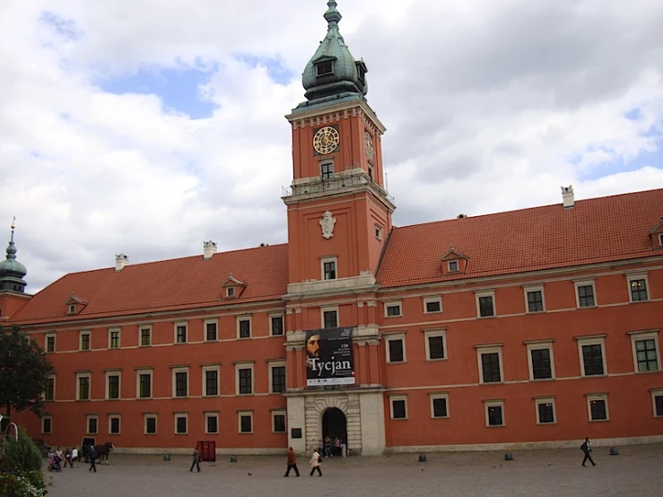 large building with clocks on red bricked walls and a tall steeple