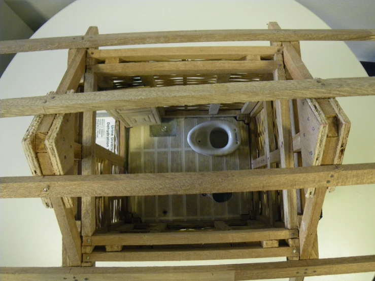 an inside view of a wooden structure with one toilet in it