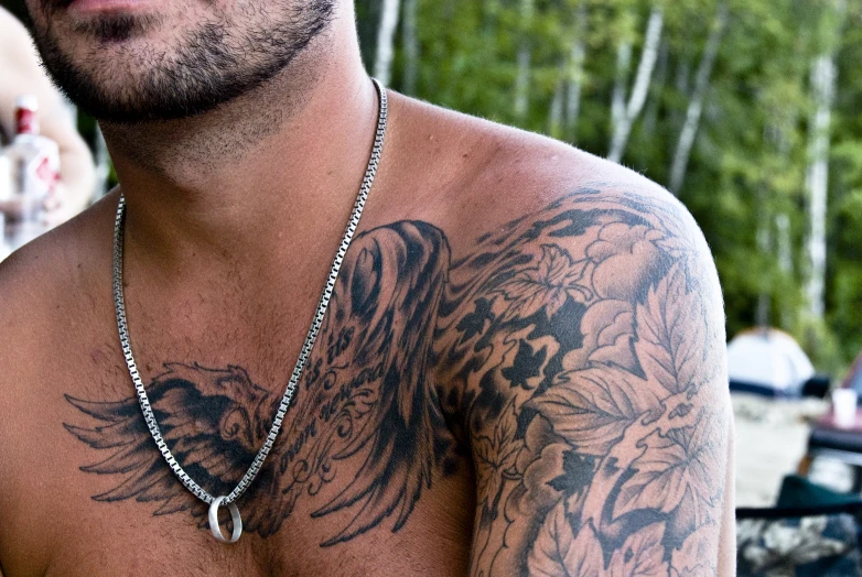 a shirtless man with tattoo and a metal chain
