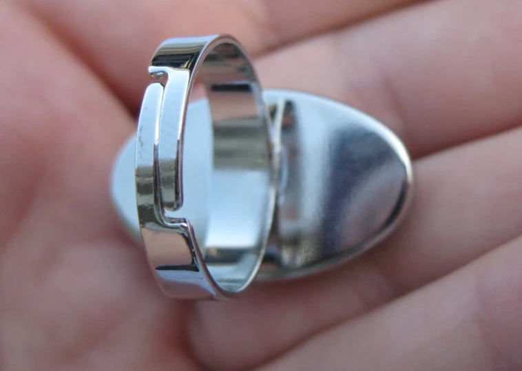 a hand that has a ring with a circular base