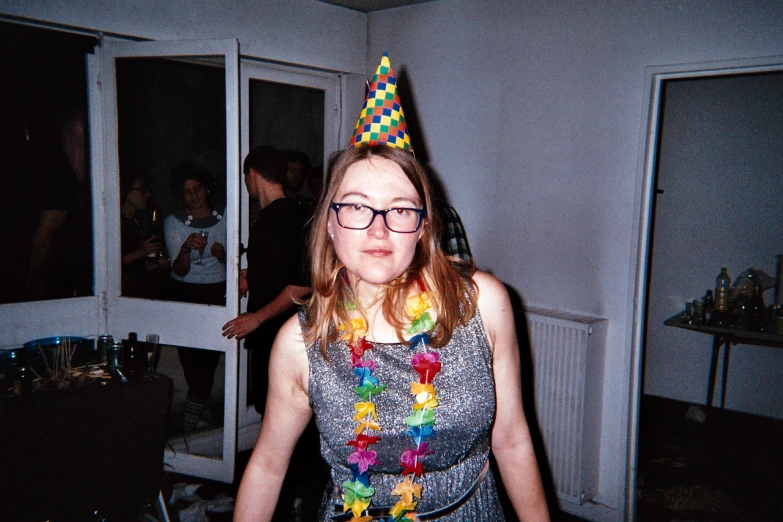 the woman is wearing glasses and a birthday hat