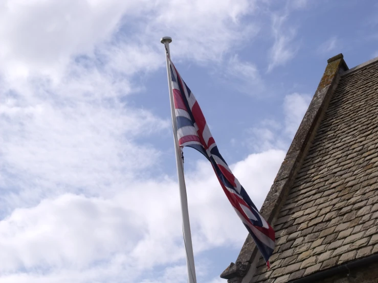 an union jack flying over a stone roof