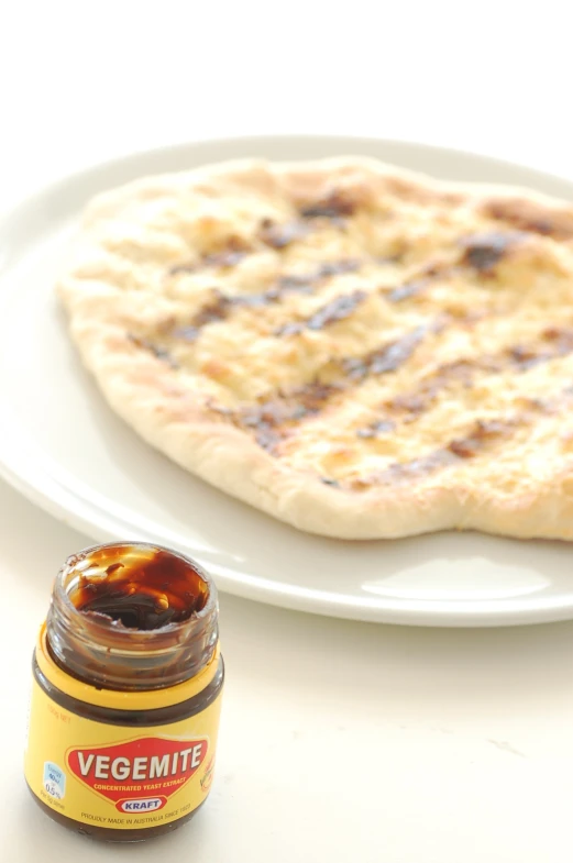 an open bottle of mustard next to a flatbread