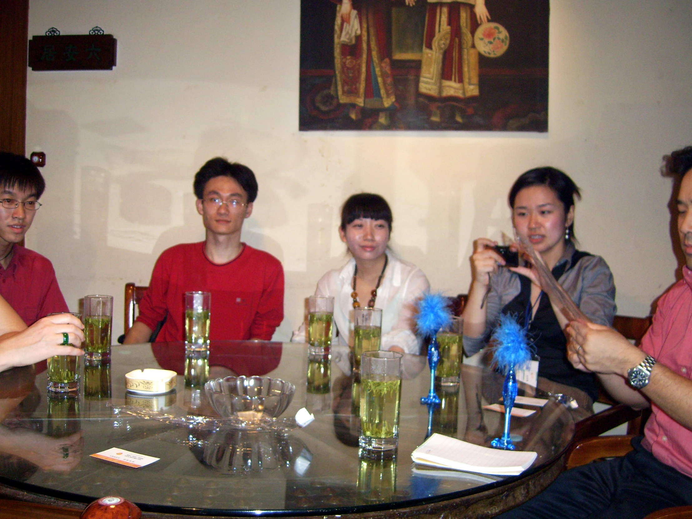 four people sitting around a table with drinks