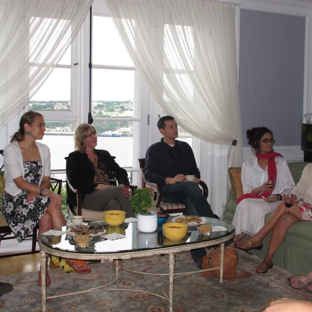 a group of people sitting and standing around a living room