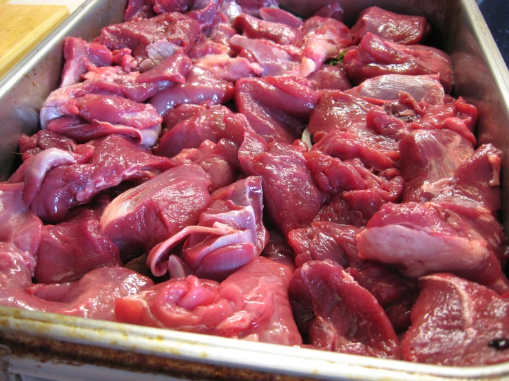 the meat is being prepared in the metal tray