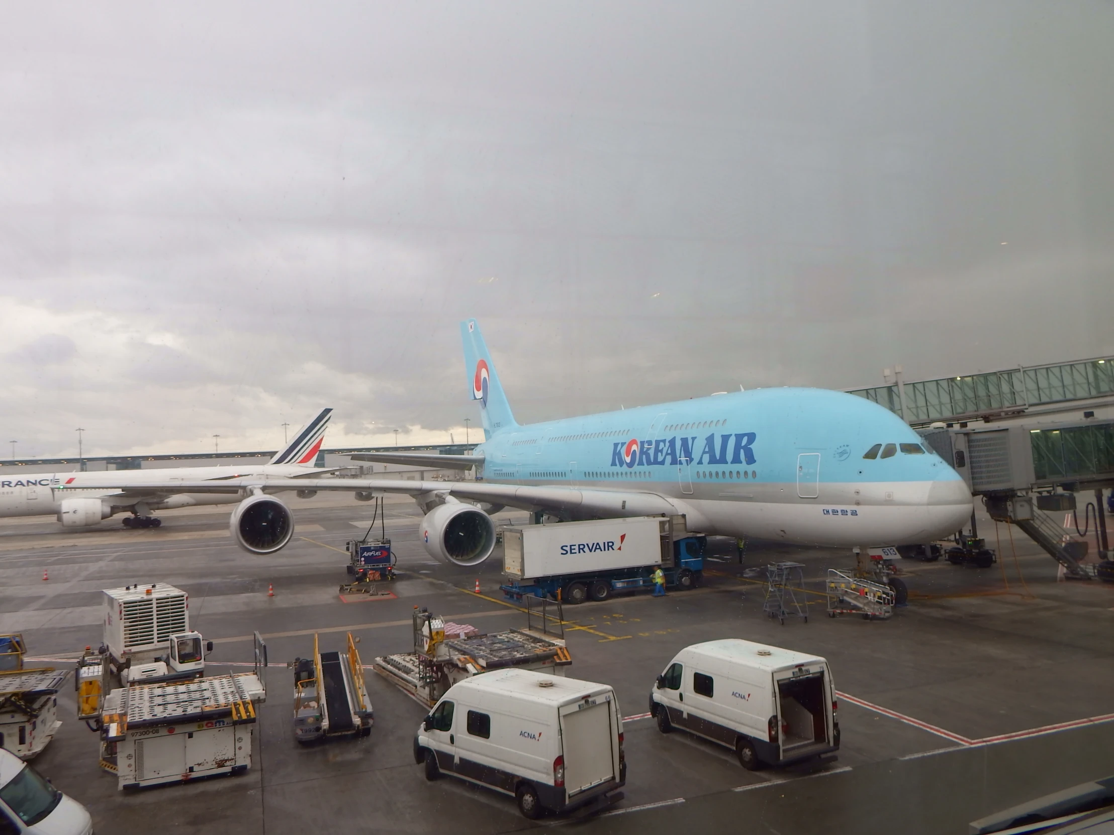 large jumbo jet with cargo cars and trucks around it