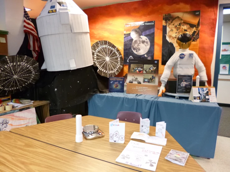 a display table with a mannequin wearing an astronaut's outfit and other space related items