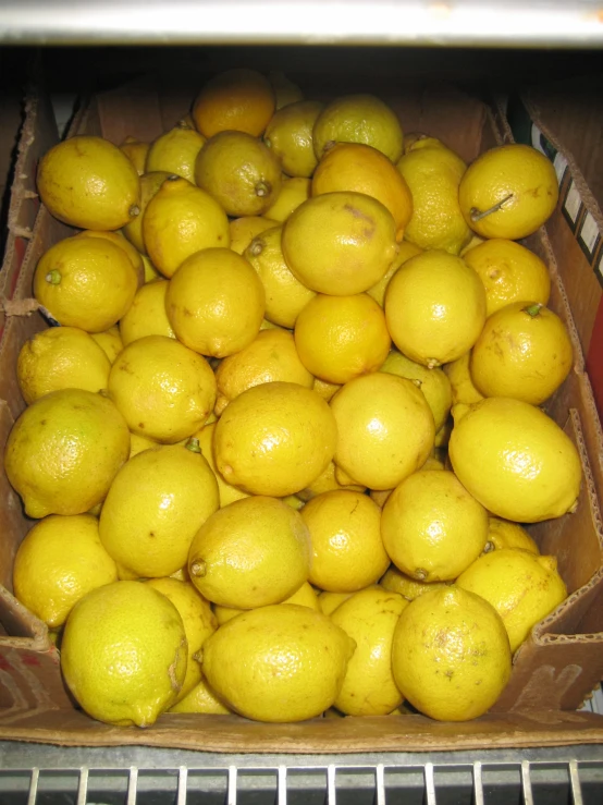 a crate full of lemons that are sitting on the floor