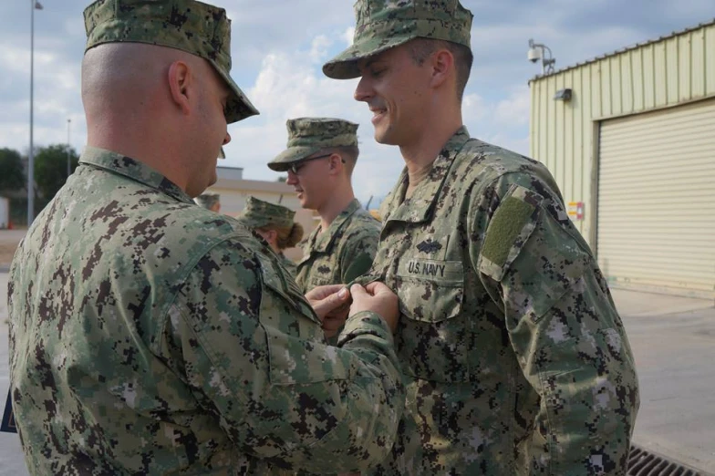 two army officers in uniform handshake each other