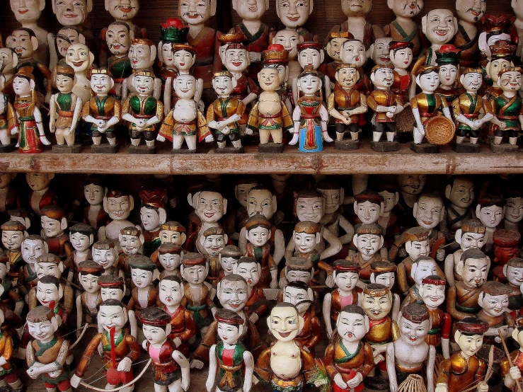 a shelf with rows and rows of faces made of various types of ceramic figures