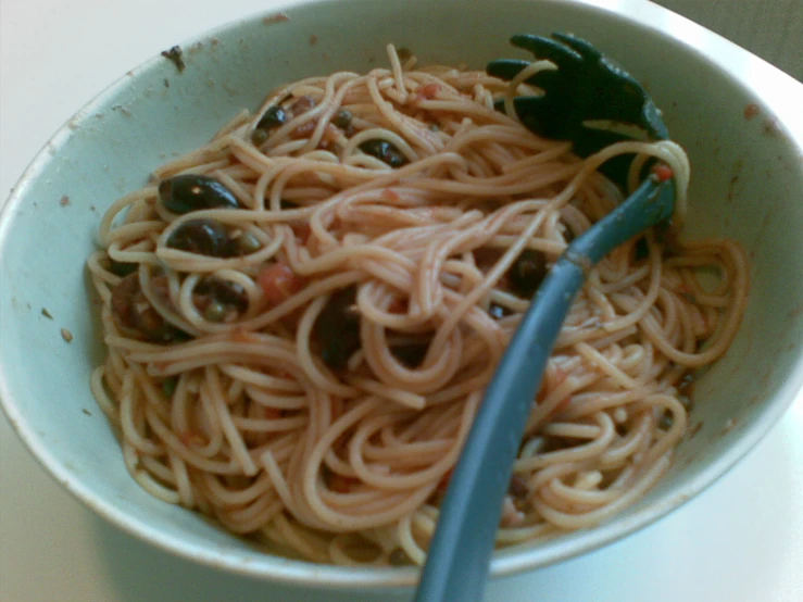 a bowl of spaghetti with olives and tomato sauce