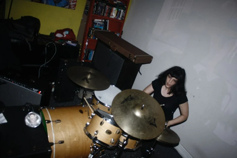 a woman playing drums in a dark room