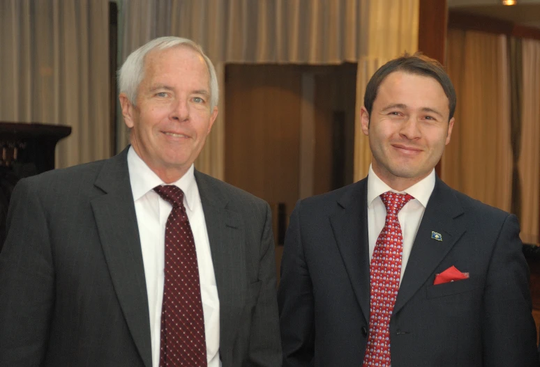 two men dressed nicely are standing near one another