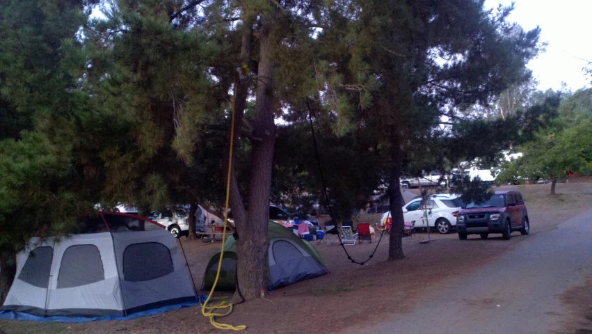 the tent and campers are camping under trees at this campsite