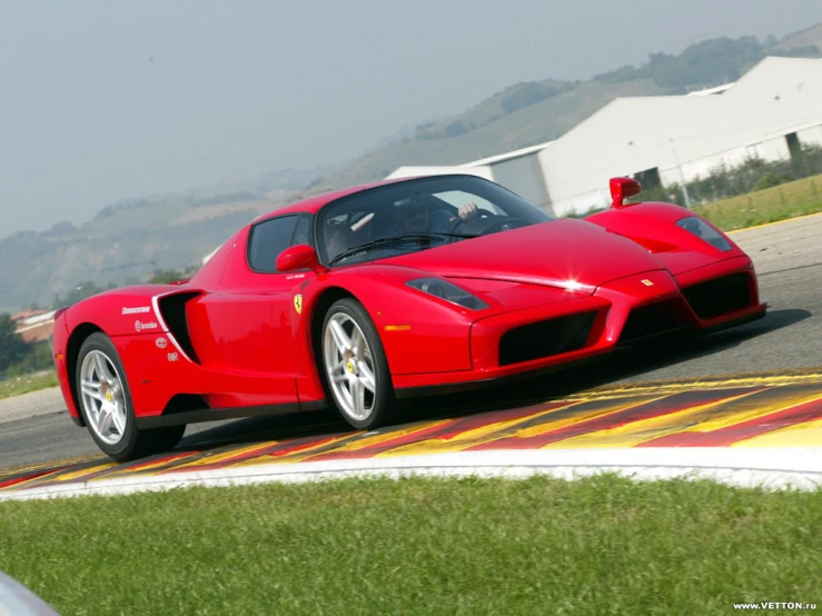 a large red car driving on a road