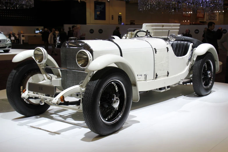 an old fashioned white car is on display