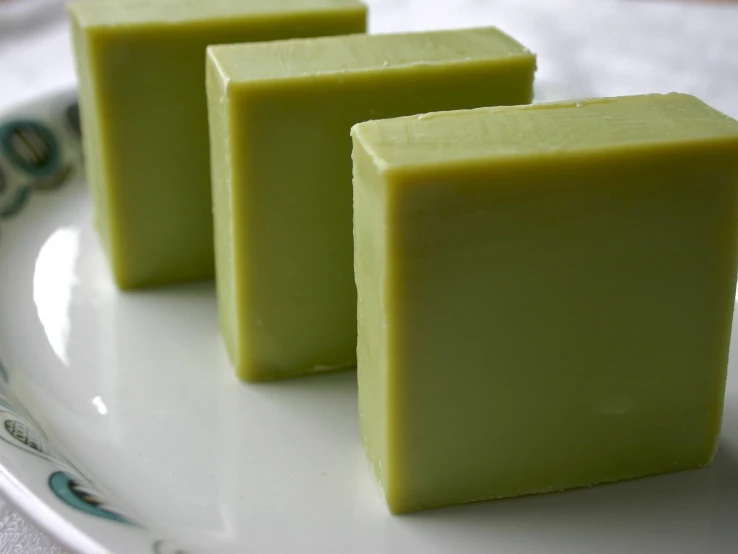 three small squares of green soap sit on a plate