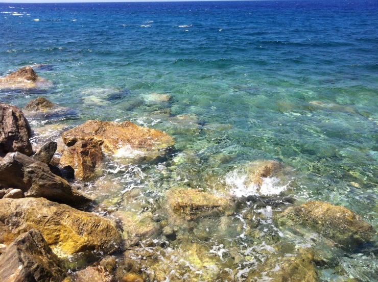 some rocks on the water and one is red