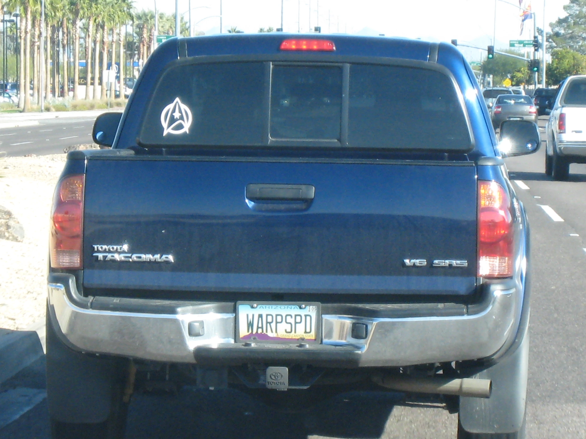 some cars on the road near palm trees