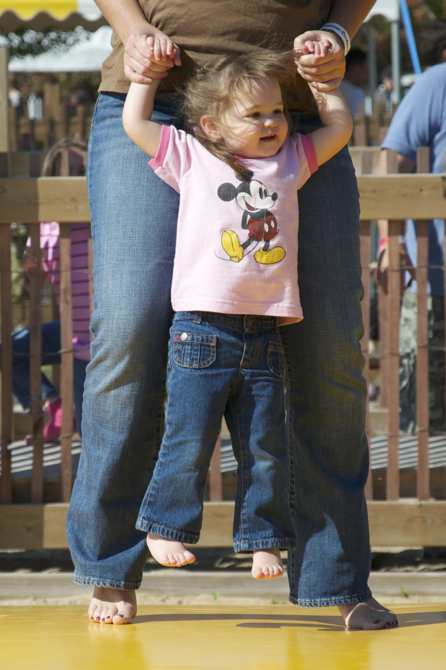 a little girl that is holding on to a girl's hand